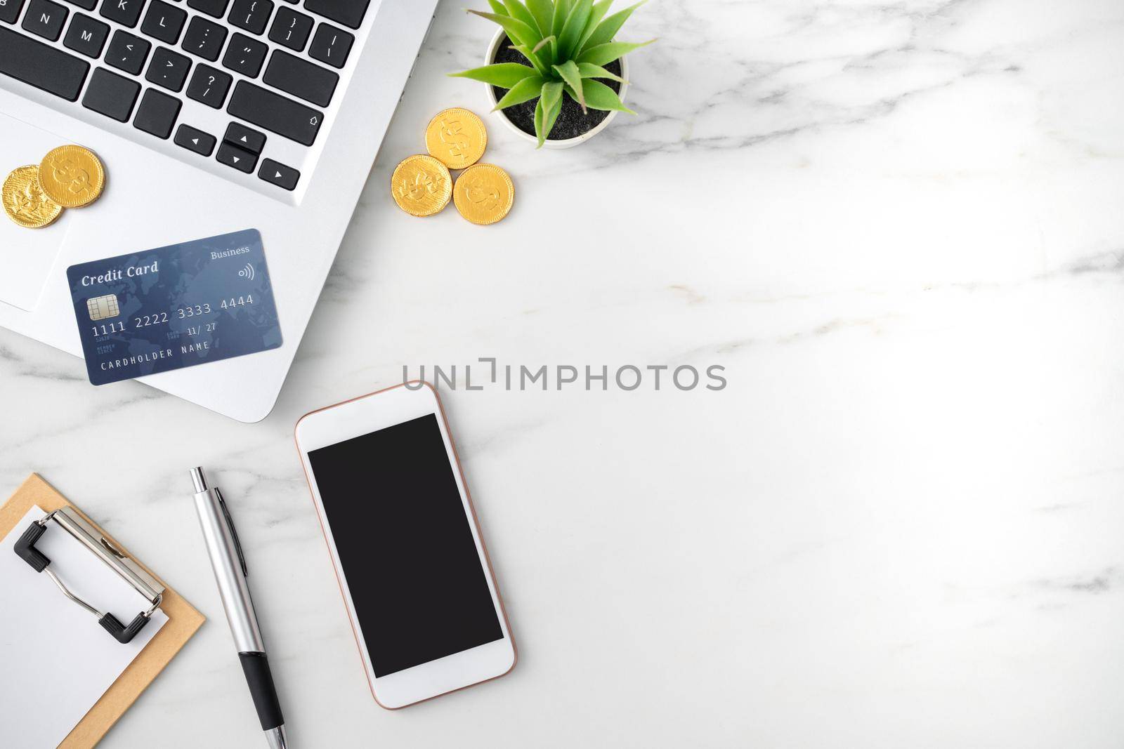 Top view of financial plan concept with credit card, laptop, note on white office table background.