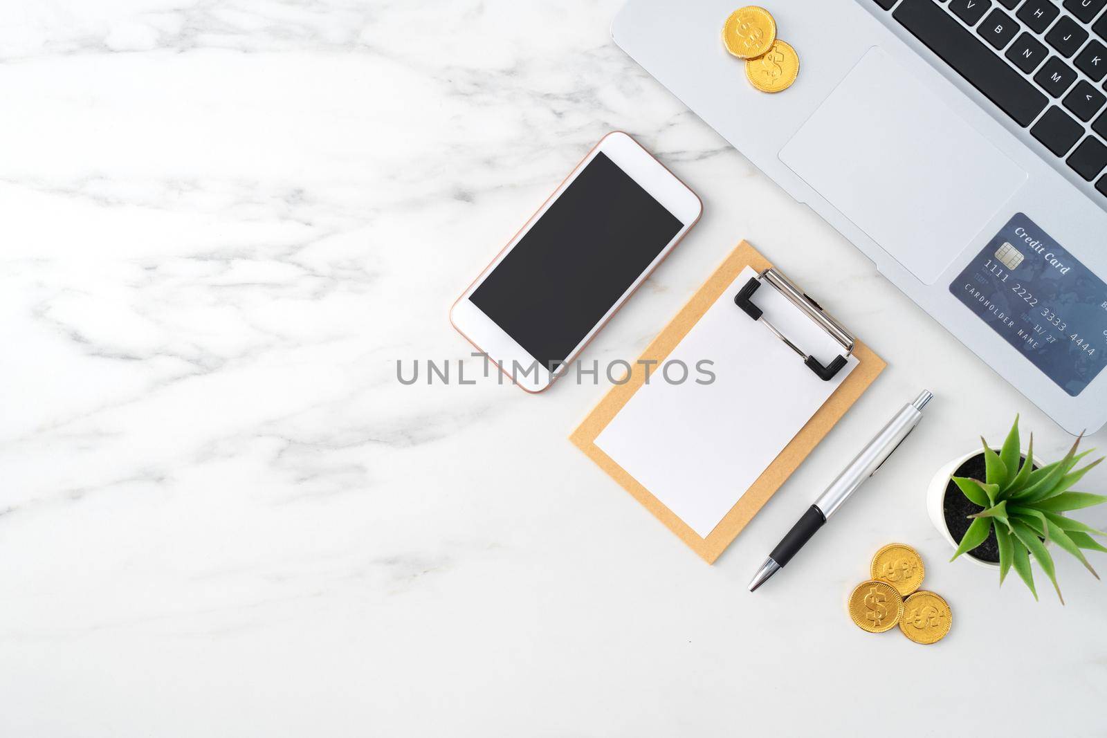 Top view of financial plan concept with credit card, laptop, note on white office table background.