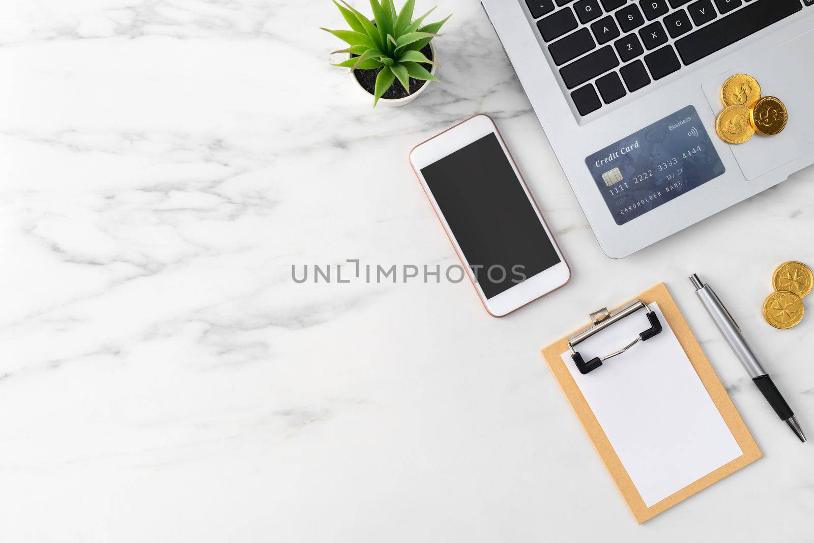 Top view of financial plan concept with credit card, laptop, note on white office table background.
