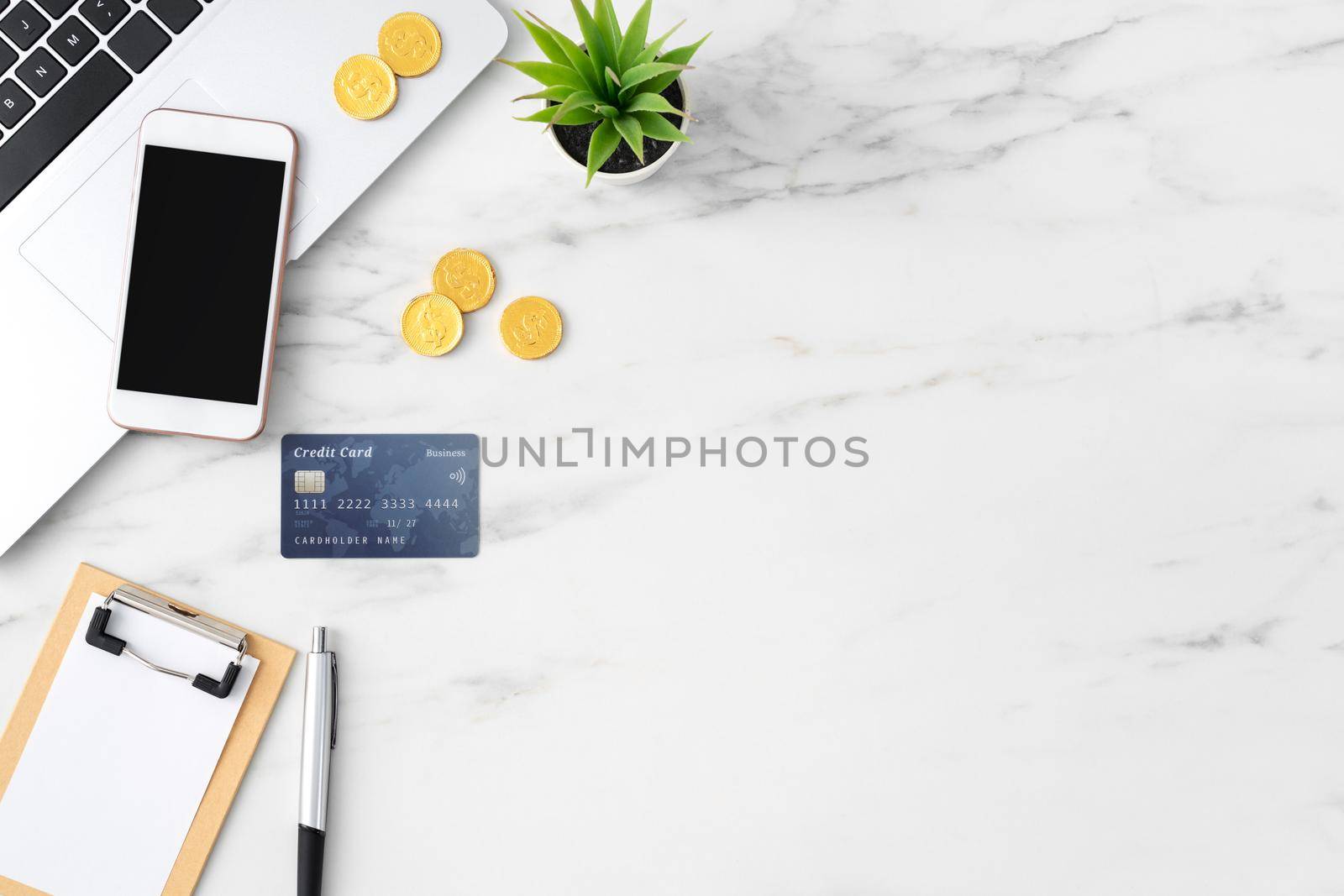 Top view of financial plan concept with credit card, laptop, note on white office table background.