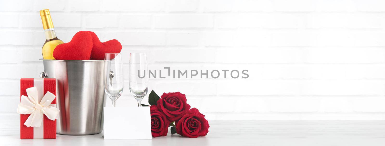 Valentine's Day celebration with wine, gift and rose bouquet for holiday greeting.