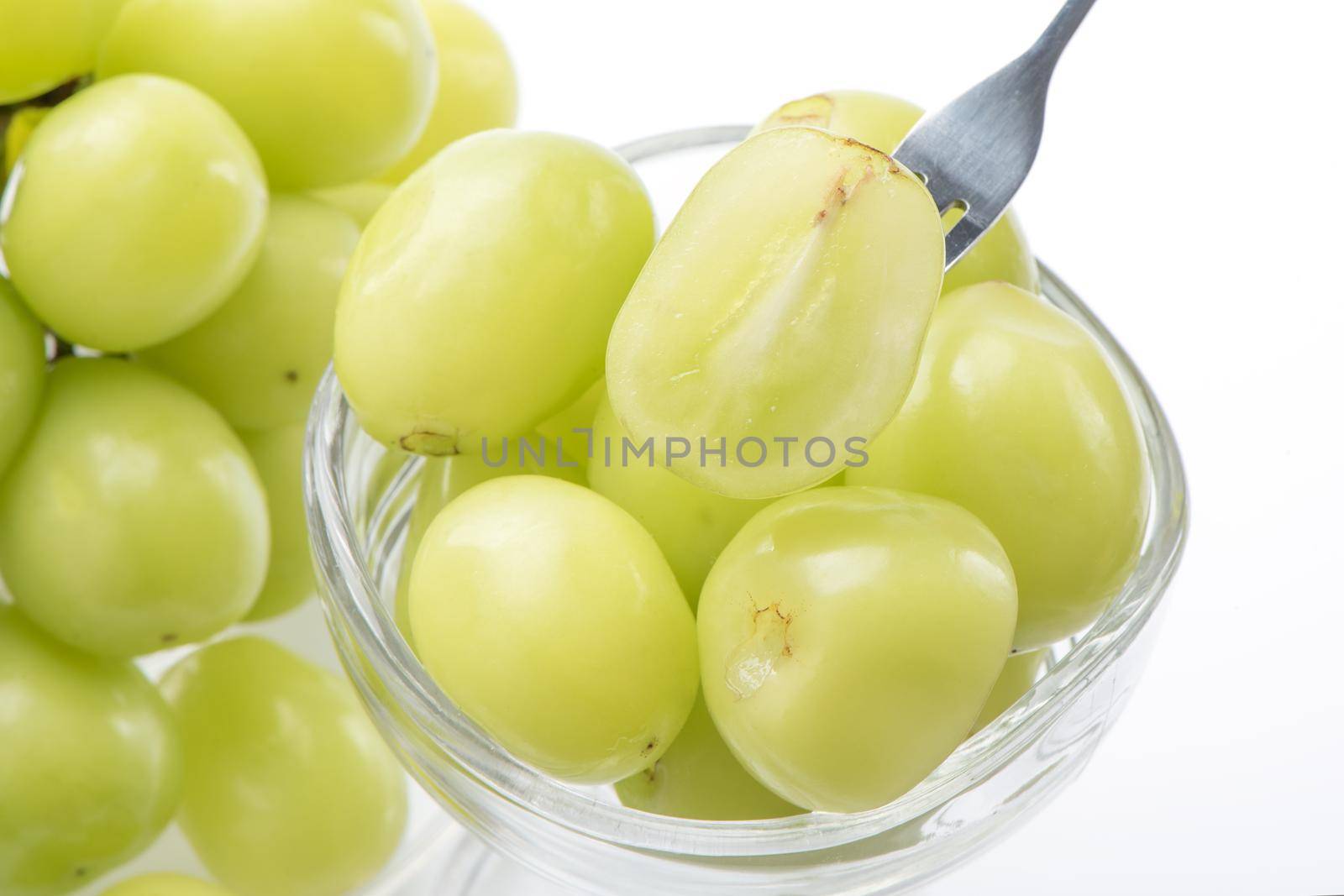 Close up of beautiful Shrine Muscat green grape in a glass cup isolated on white background, clipping path cut out.