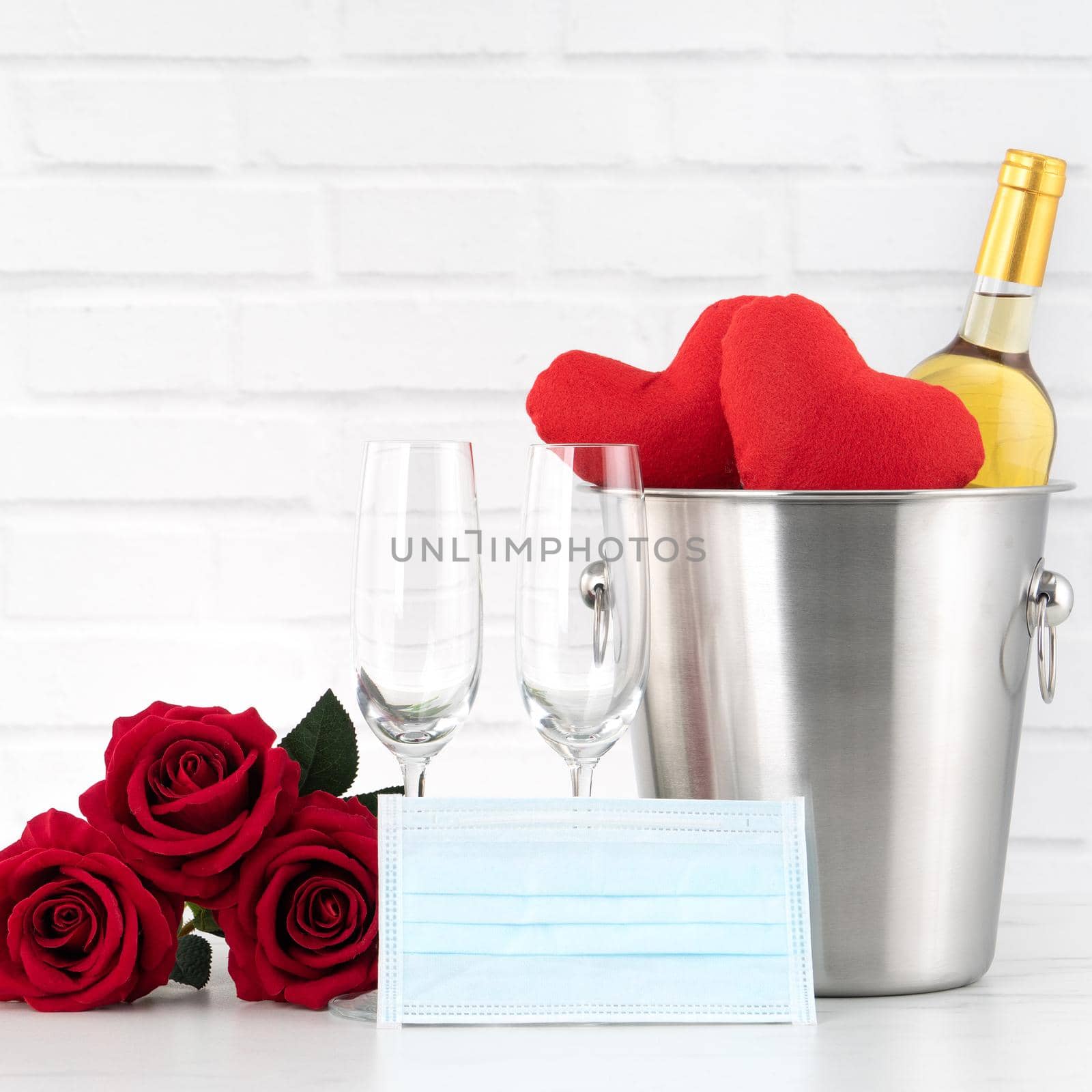 Valentine's Day celebration with wine, bouquet and face mask protection concept during this hard time.