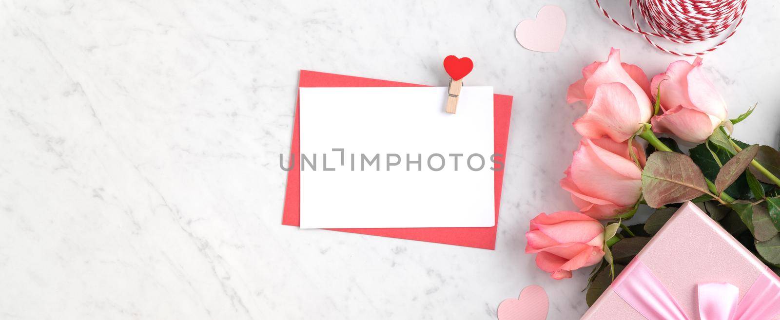 Valentine's Day design concept background with pink rose flower and gift box on marble white background