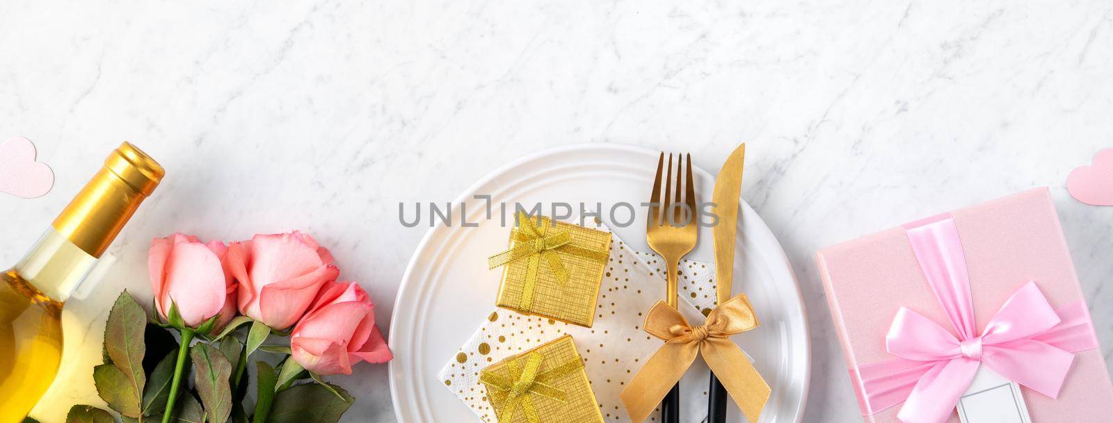 White plate with gift and pink rose flower on marble white table background for Valentine's Day special holiday dating meal concept.