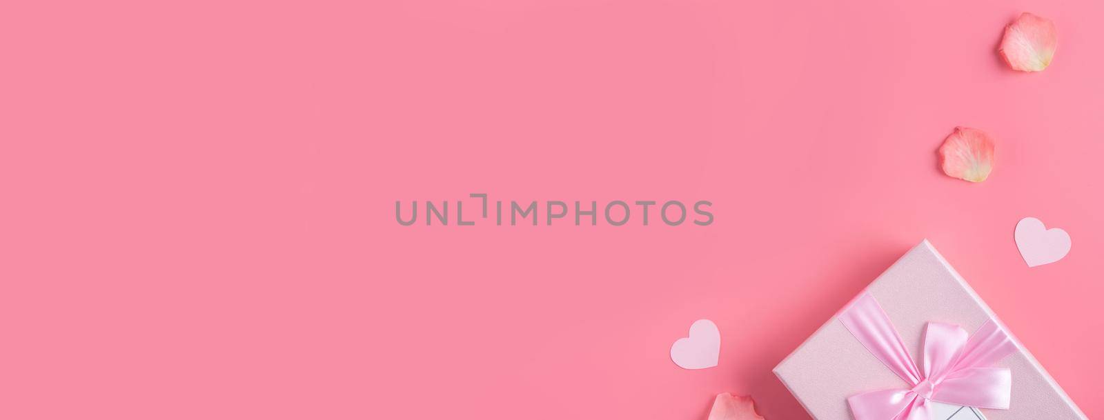 Valentine's Day design concept background with pink petals and gift box. by ROMIXIMAGE