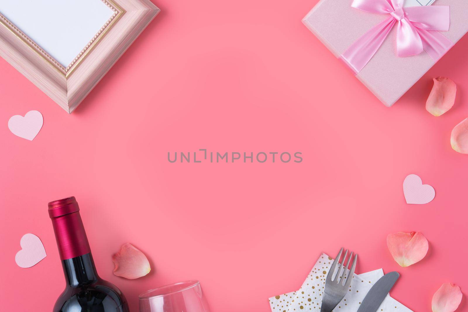 Valentine's Day design concept background with pink petals and gift box on pink background