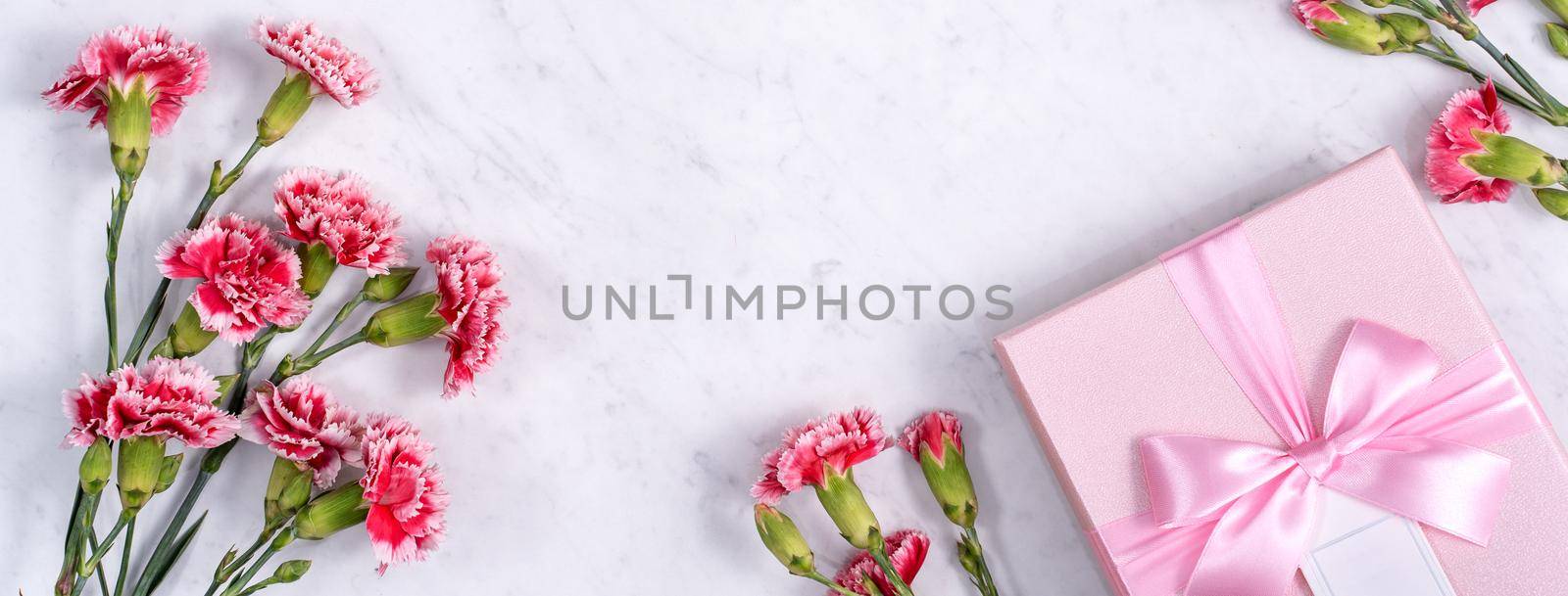 Top view of Mother's Day background design concept with carnation flower bouquet on marble table