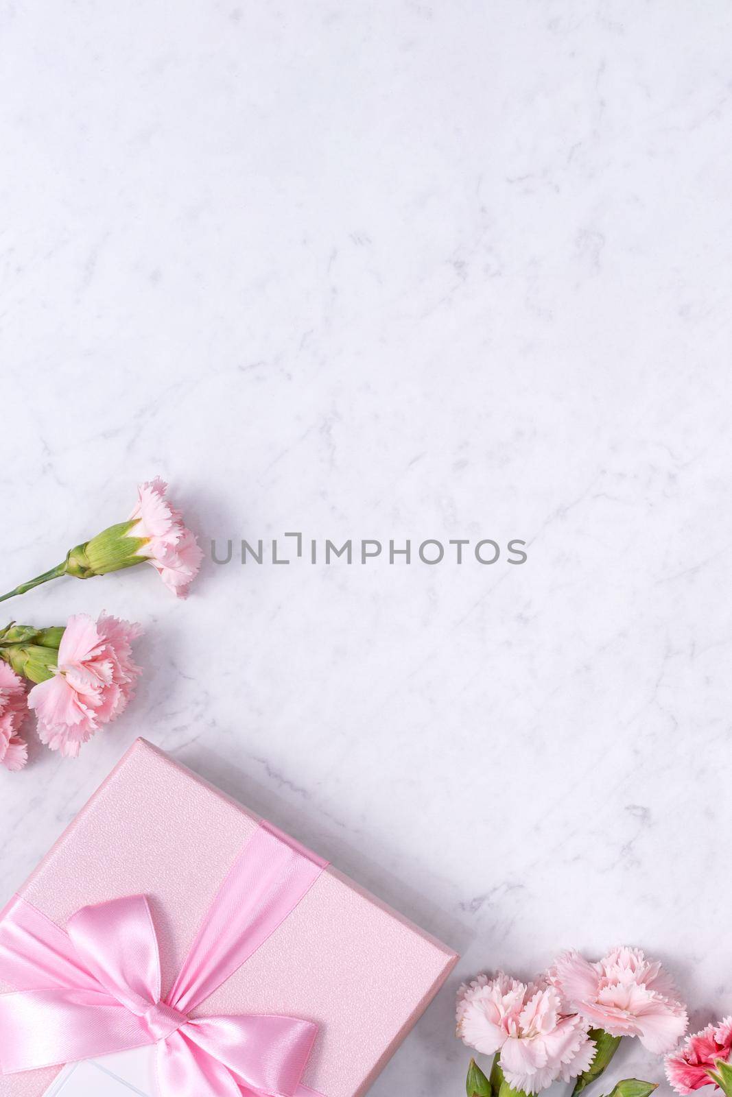 Top view of Mother's Day background design concept with carnation flower bouquet on marble table