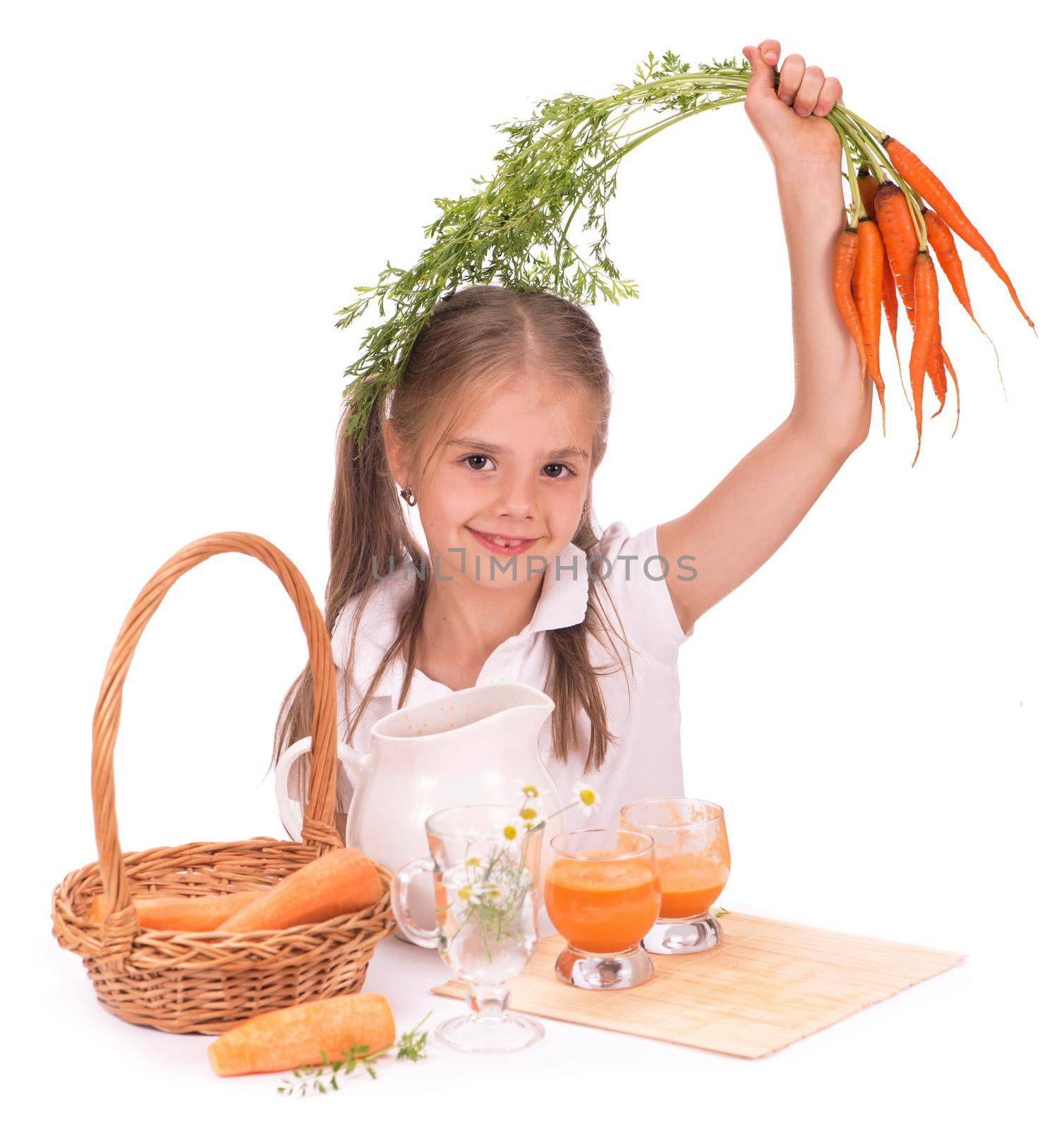 Nice blond baby girl with glass of carrot juice