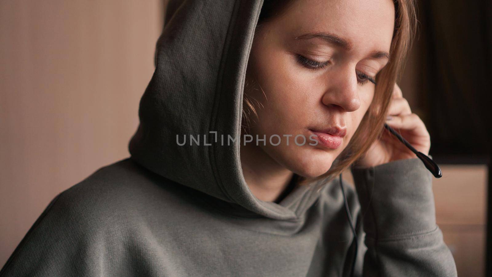Portrait of a young girl in a hoodie and with a headset. Call center worker by natali_brill