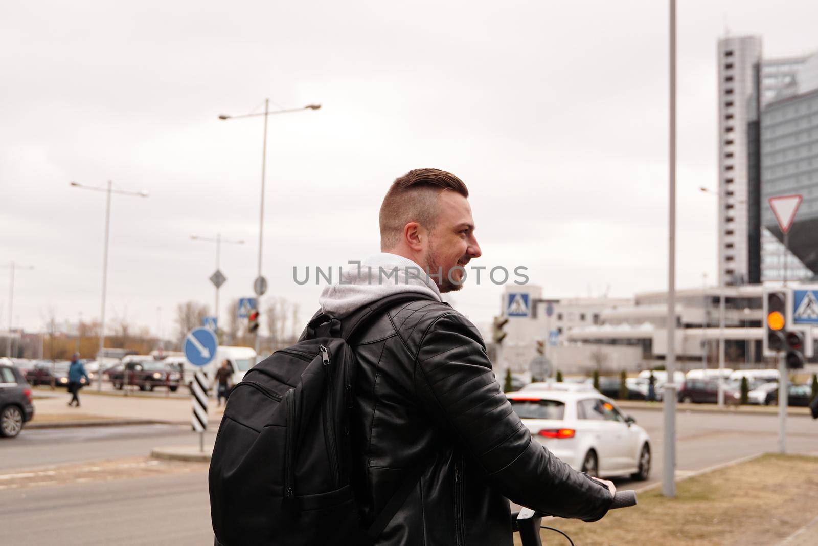 Young man with backpack on his back riding on scooter by natali_brill