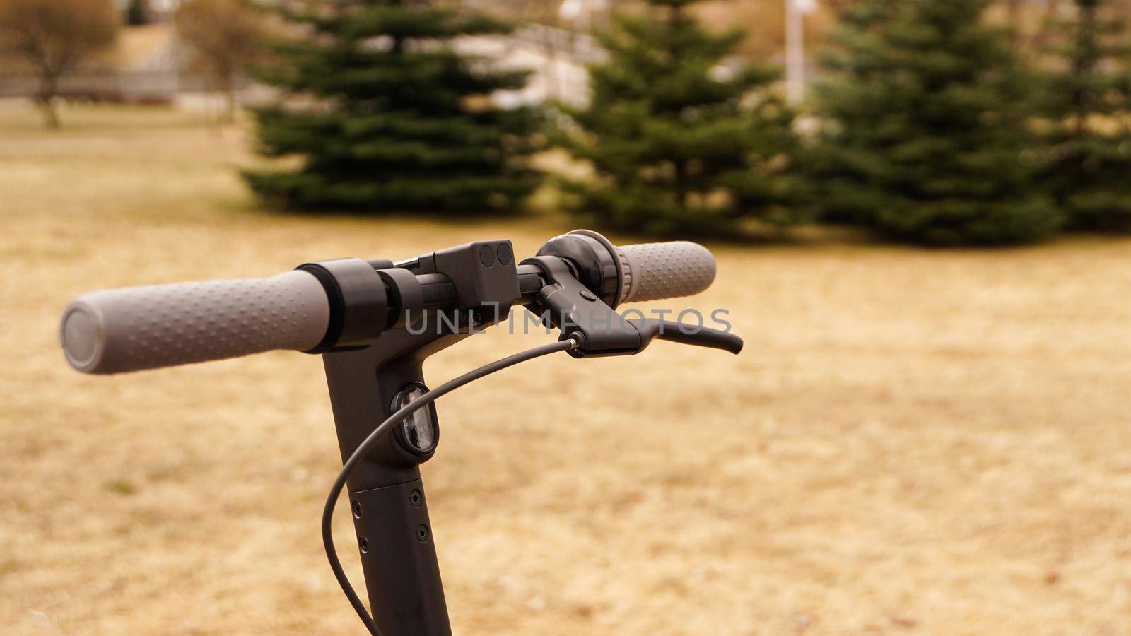 Close-up of the steering wheel of an electric scooter outside. The beginning of the spring season for scooter riding.