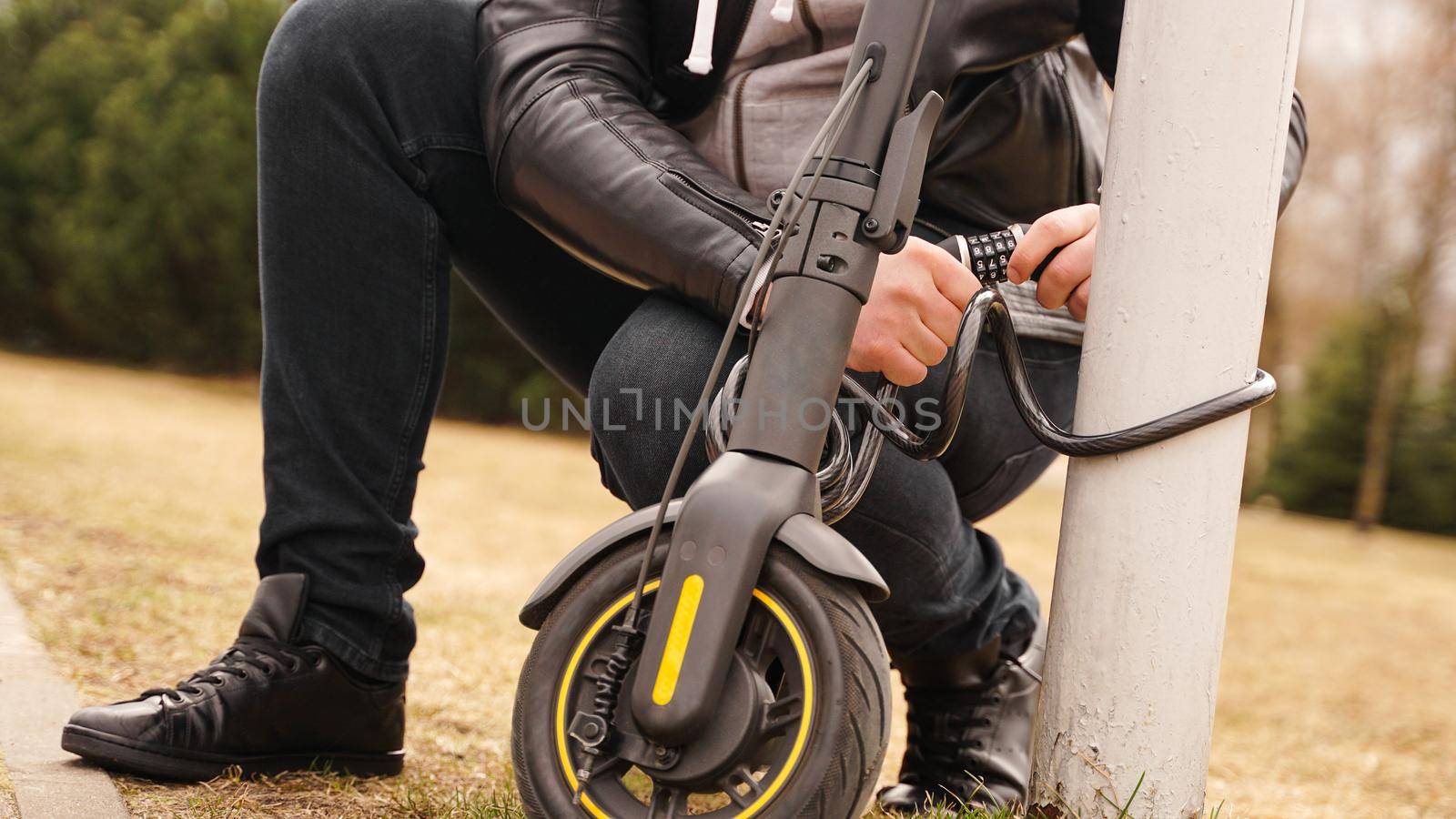 Closeup photoshoot of man which is locking his scooter with locker. Anti-theft combination code lock
