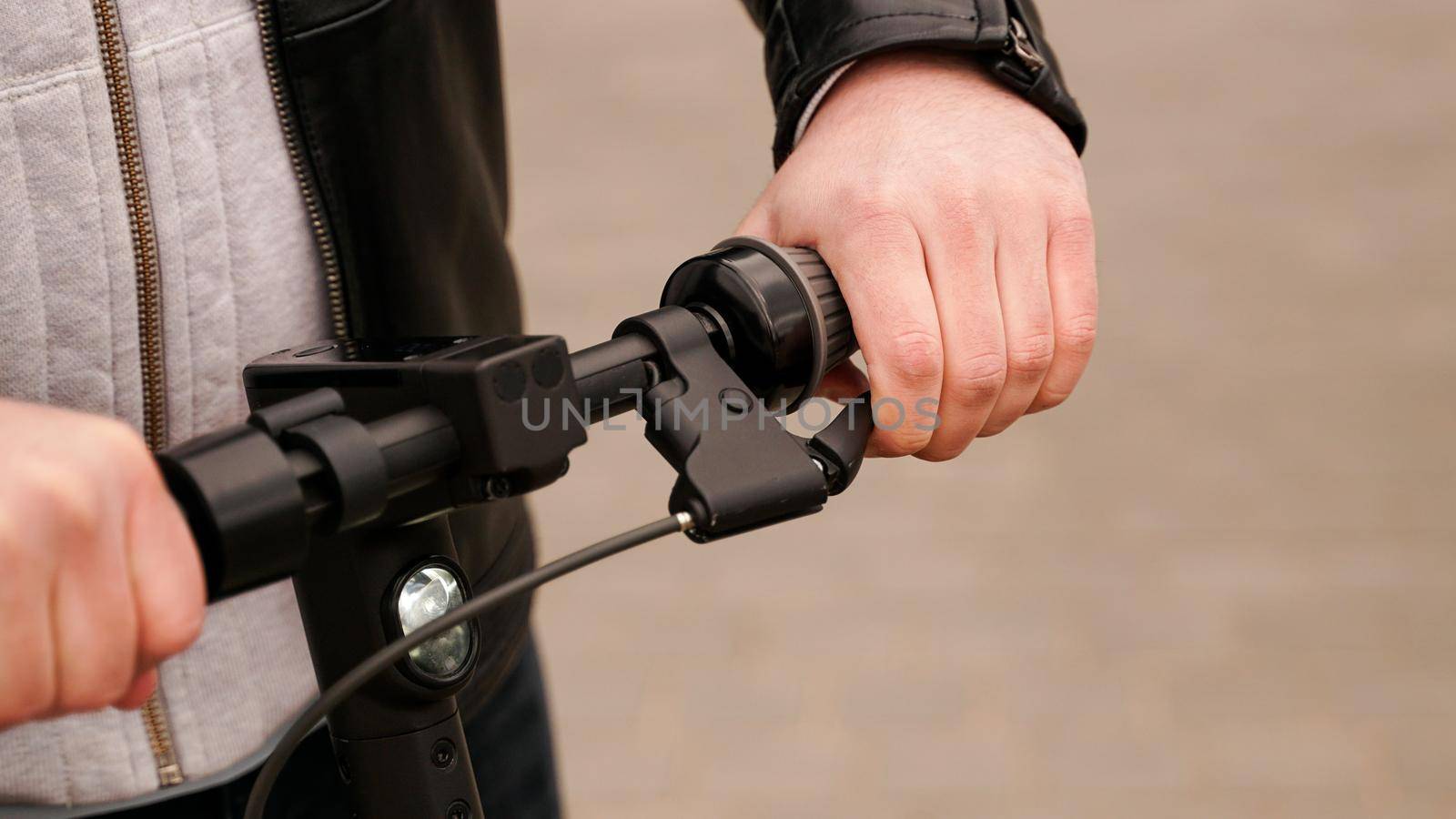 Electric scooter handlebar and man hand on the lever during brake check before scooting and practicing riding