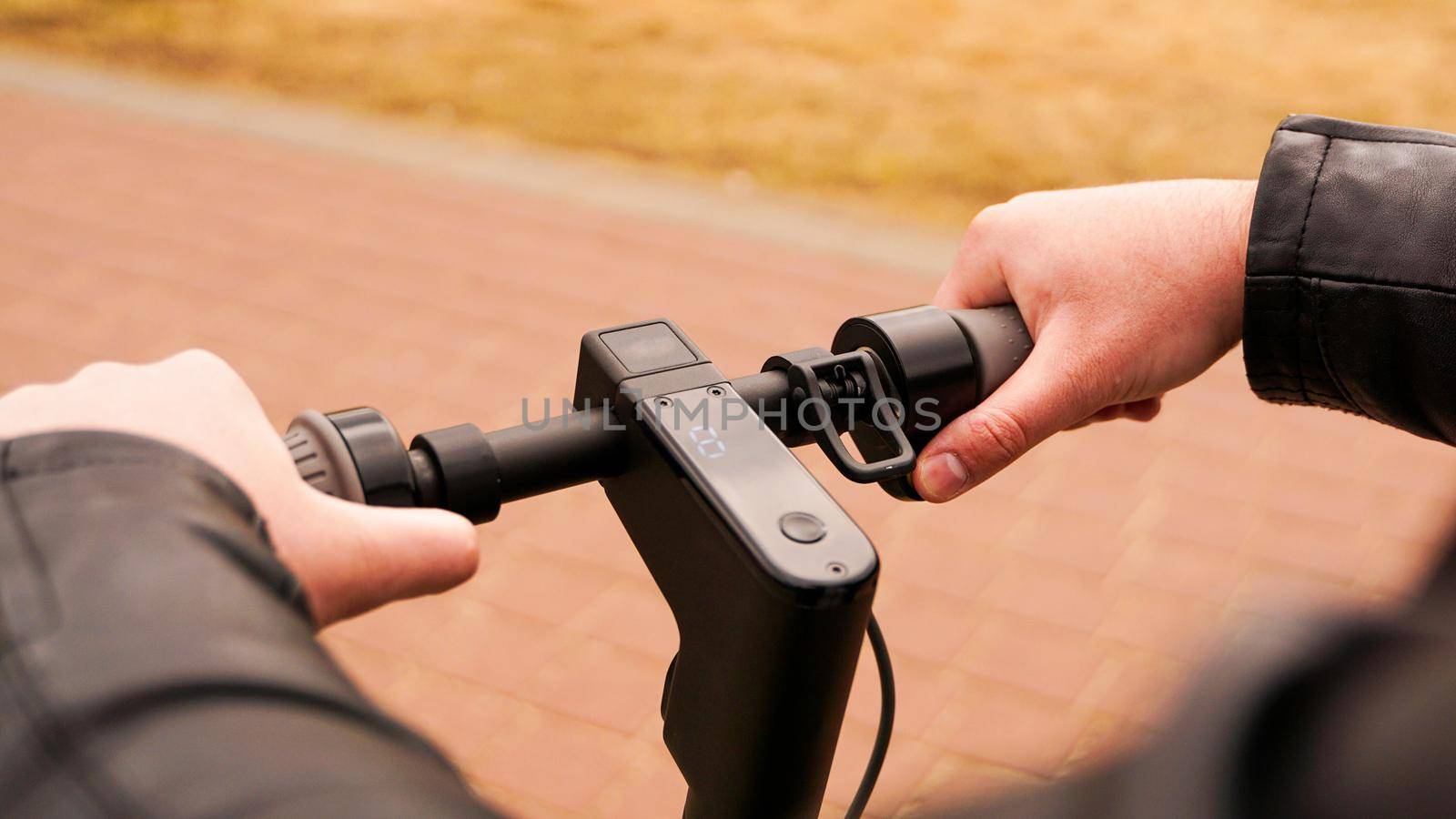 Close-up of male hand pressing speed button on electric scooter by natali_brill