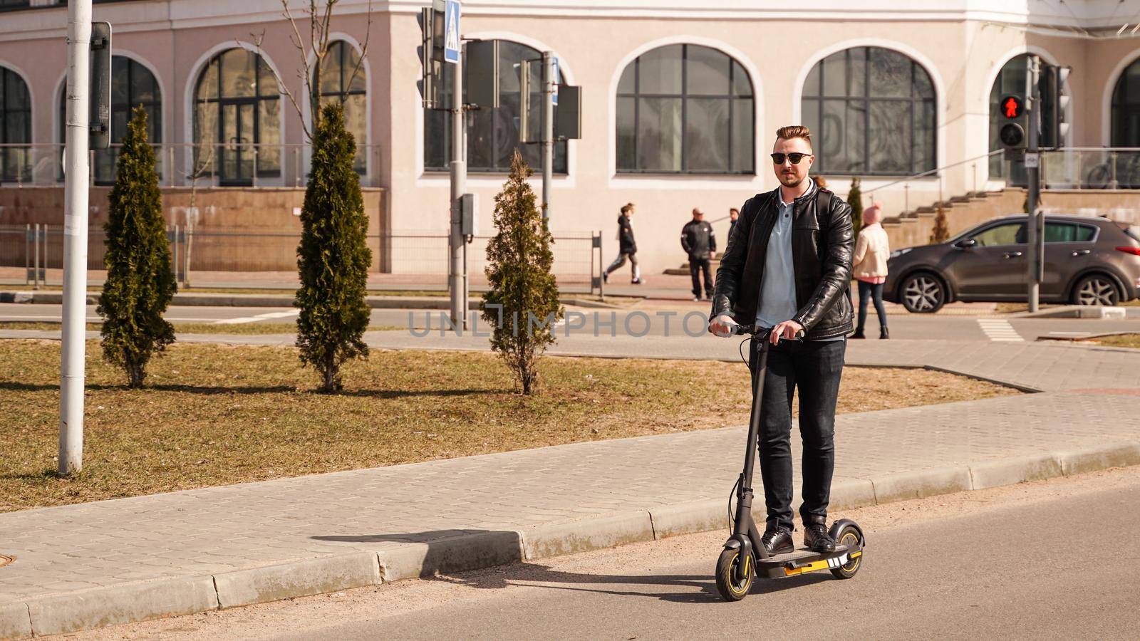 Modern man riding electric scooter in the city by natali_brill
