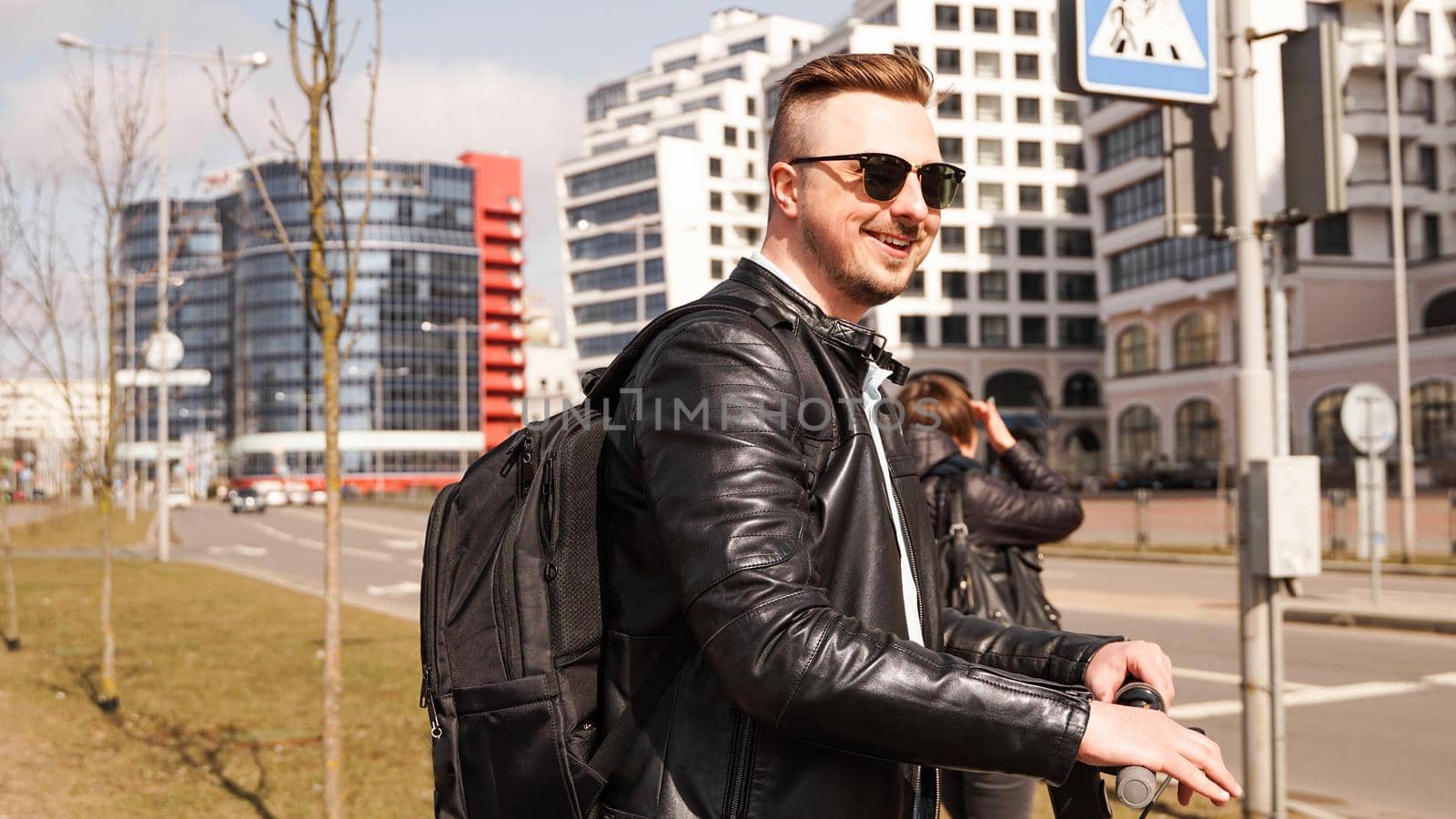 A smiling guy in sunglasses stands at the crossroads by natali_brill