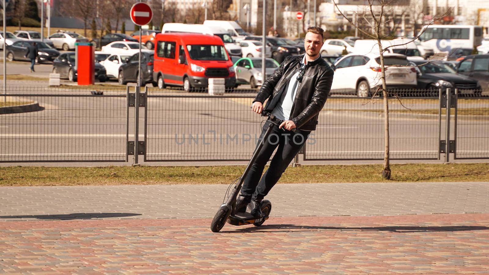 Modern man riding electric scooter in the city by natali_brill