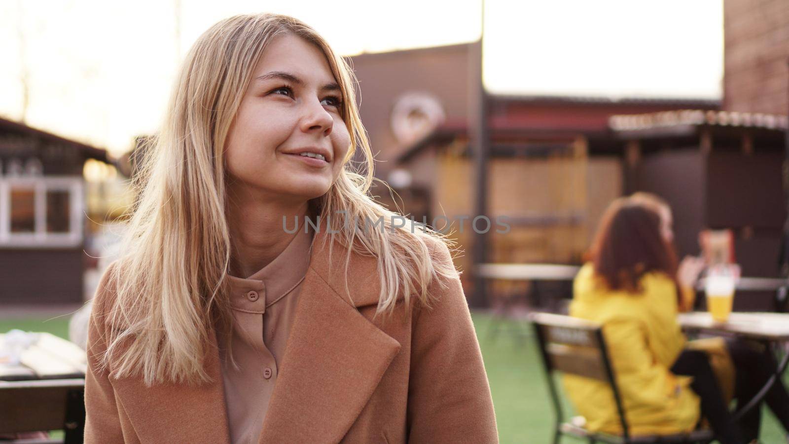 Portrait of a young woman in the city. City food court with street food. Portrait of a smiling blonde. Lifestyle photo