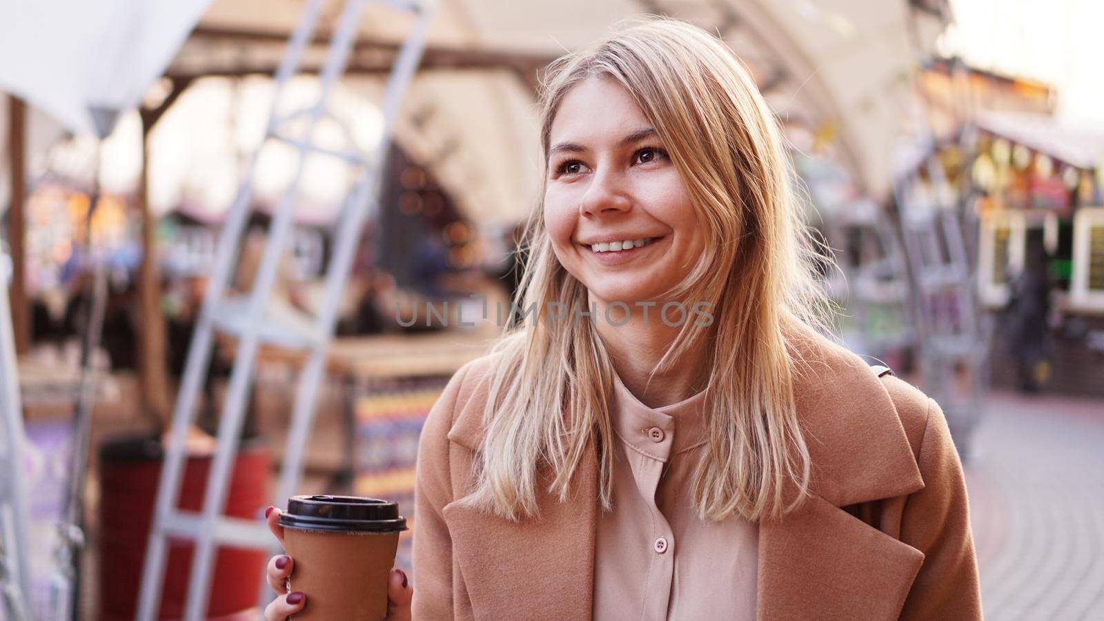 Young blonde with a cup of coffee. Woman at the food court. Lifestyle photo. Beautiful woman drinking coffee