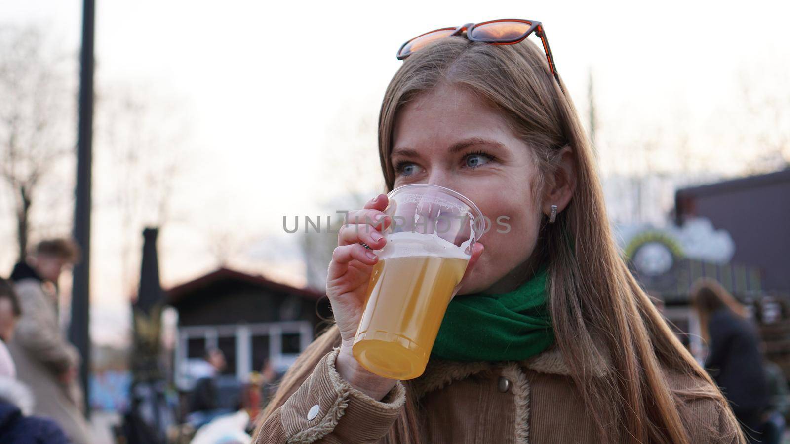 Young woman drinks light beer. Street food and food court. by natali_brill