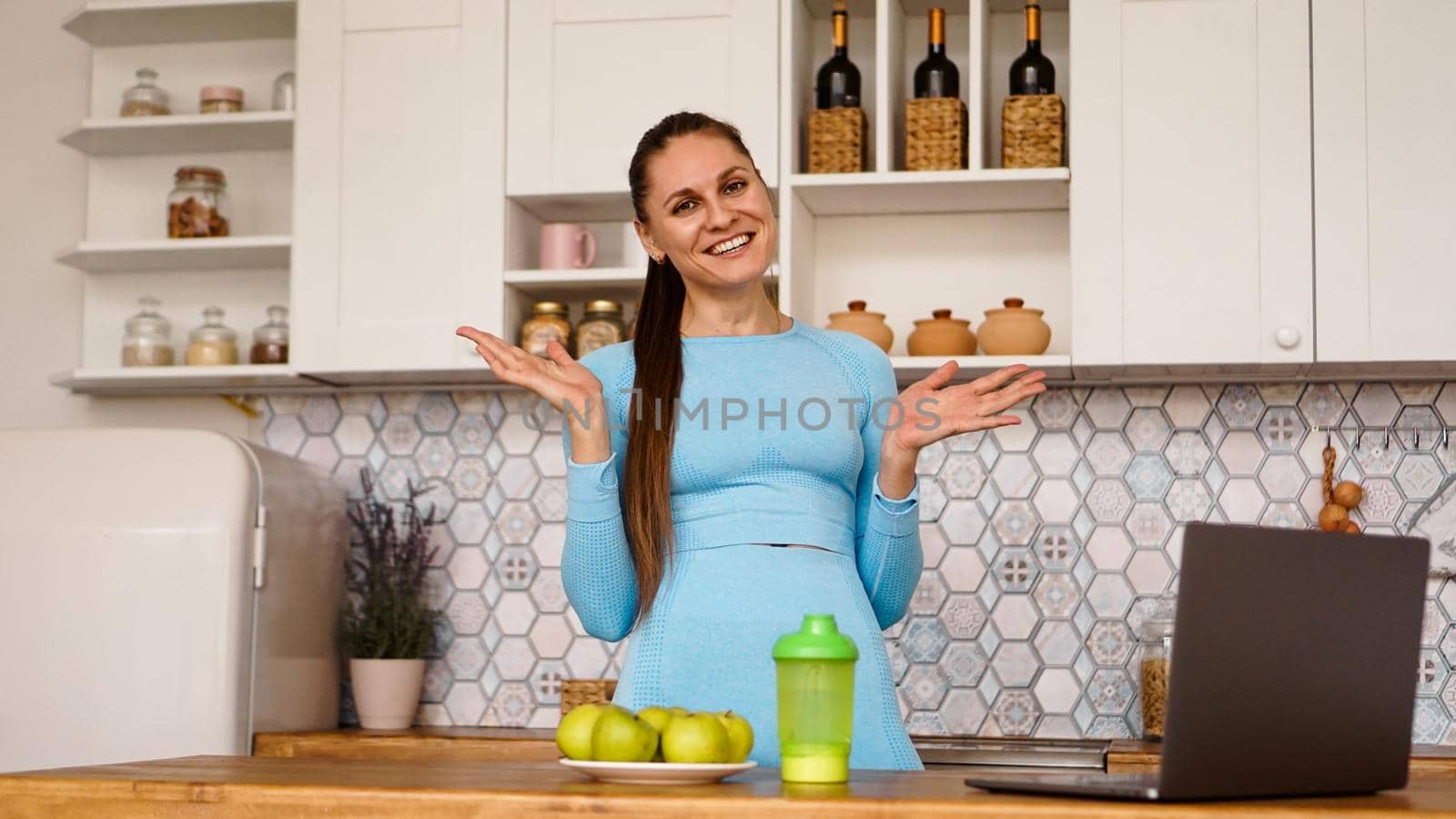 Smiling woman using computer in modern kitchen. Healthy lifestyle concept by natali_brill