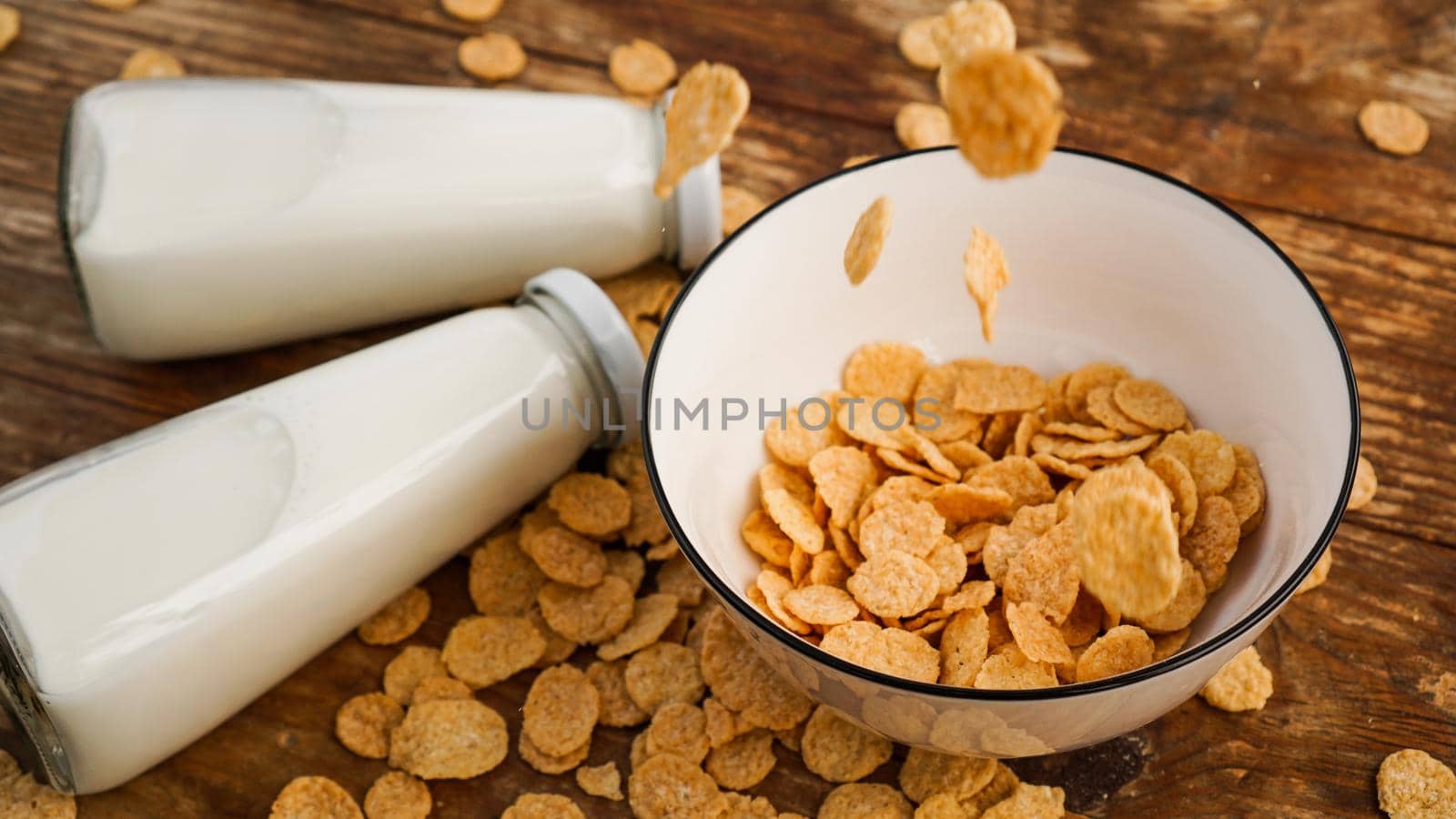 Healthy eating background. Dry flakes fall into a bowl. Wood background