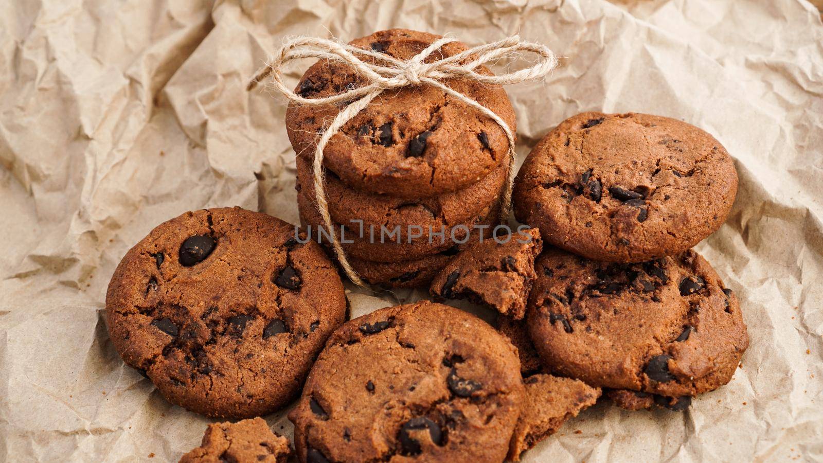 Flatview of handcrafted chocolate cookies with chocolate chips on baking paper. Natural handmade organic snakes for healthy breakfast