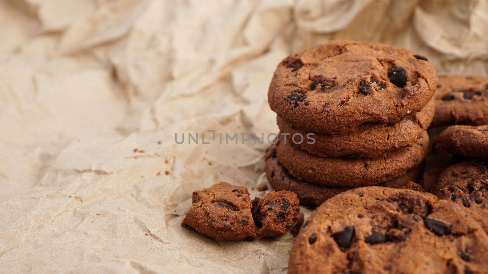 Flatview of handcrafted chocolate cookies with chocolate chips on baking paper. Natural handmade organic snakes for healthy breakfast