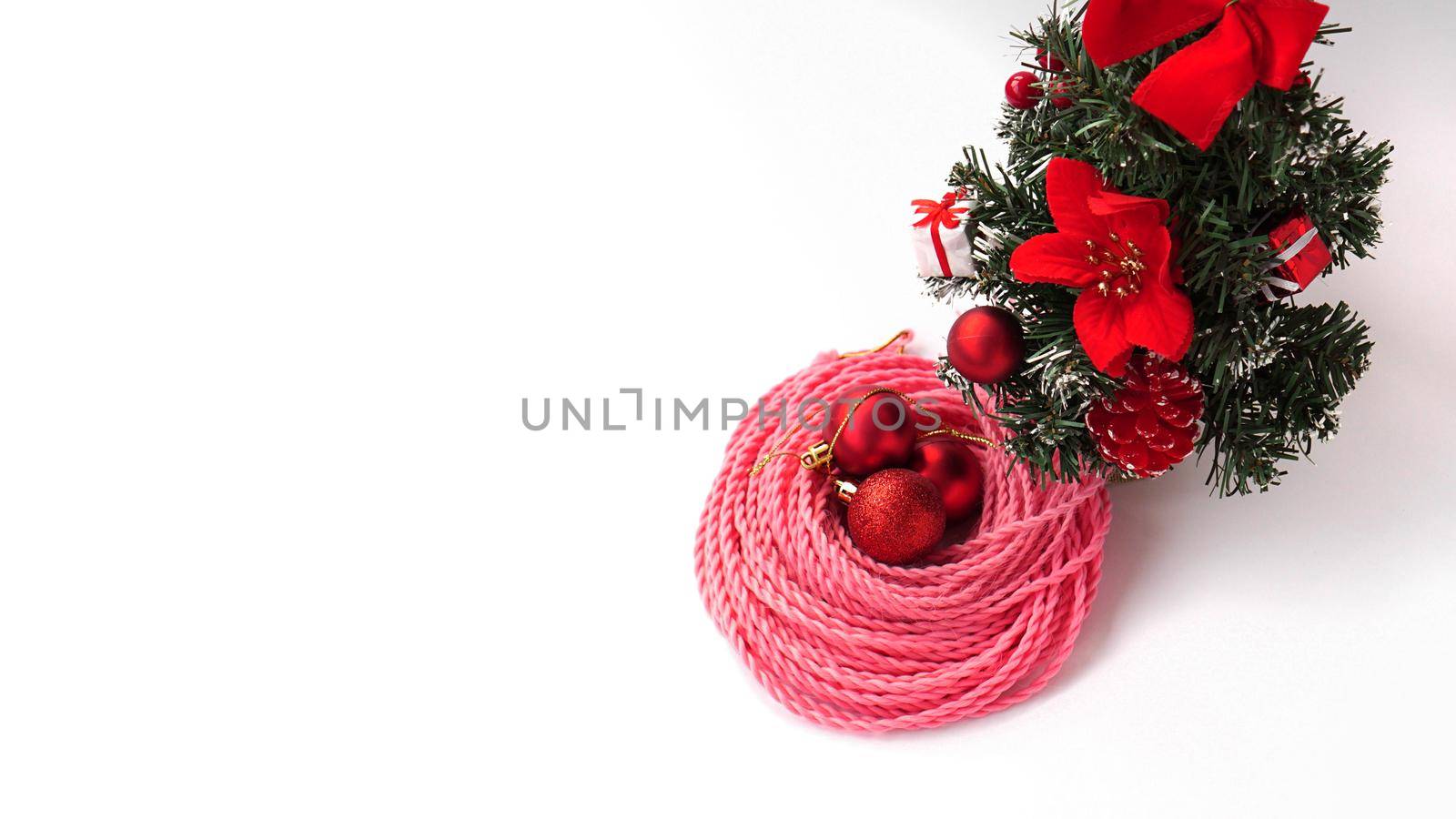 Synthetic pink kanekalon braids - Christmas photo with decoration on white. New Year photo for a store or hairdressing salons, barbershops