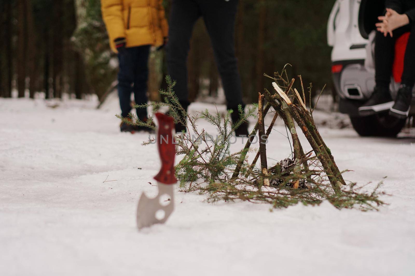 Tourist knife and bonfire in the winter forest. Tourists at rest