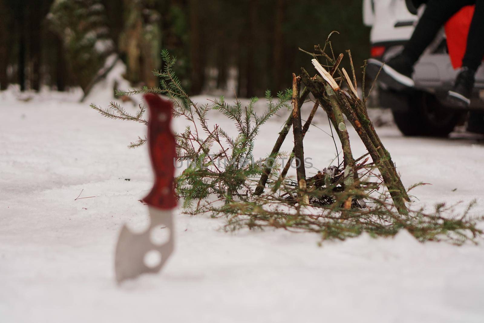 Tourist knife and bonfire in the winter forest. Tourists at rest