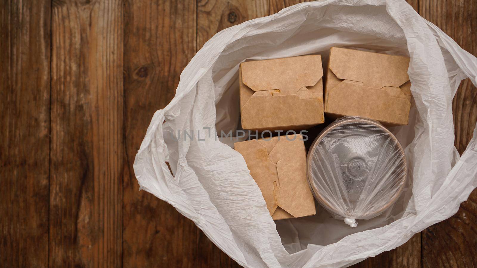 Asian food delivery. Food in containers and in a package on a wooden background. Japanese food and sushi packaging.