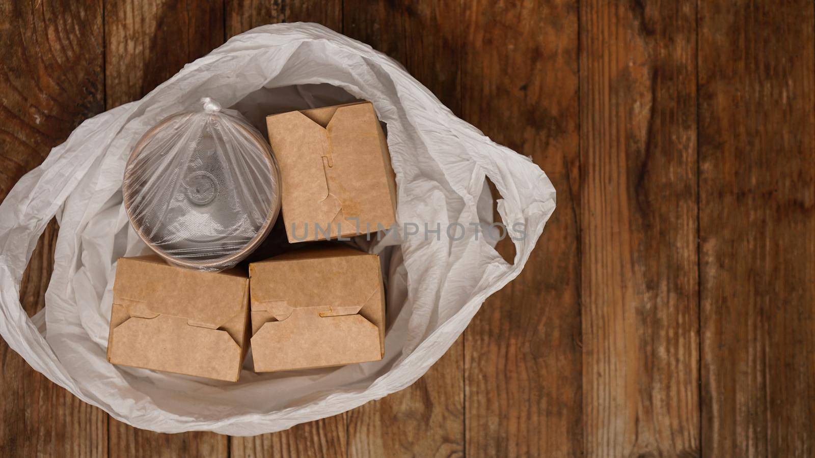 Asian food delivery. Food in containers and in a package on a wooden background. Japanese food and sushi packaging.