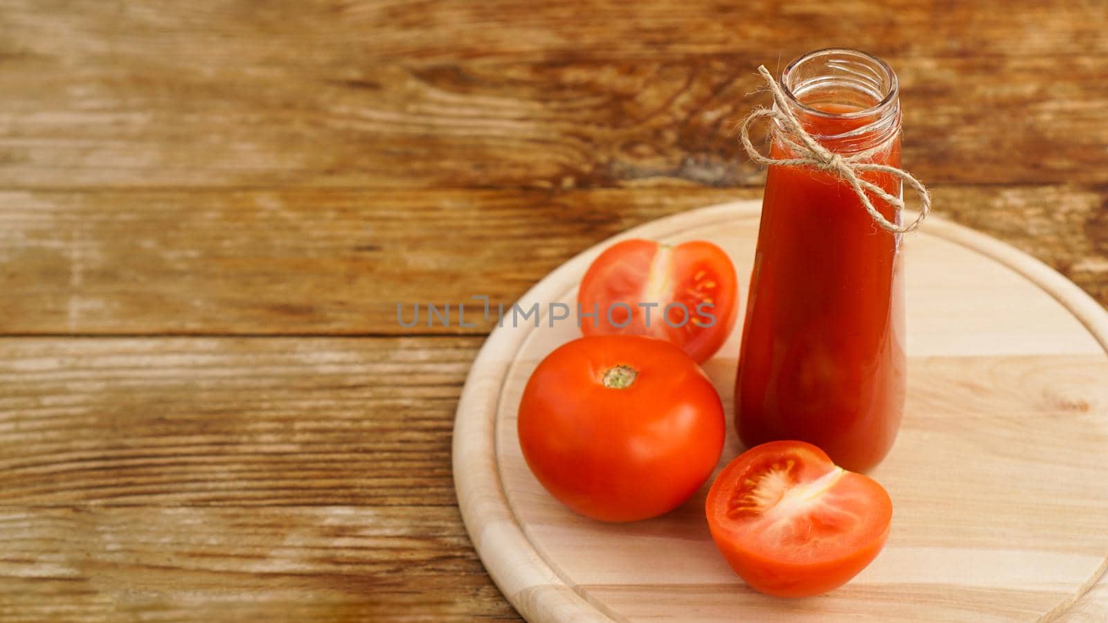 Tomato juice, fresh tomatoes on wooden background - horizontal photo