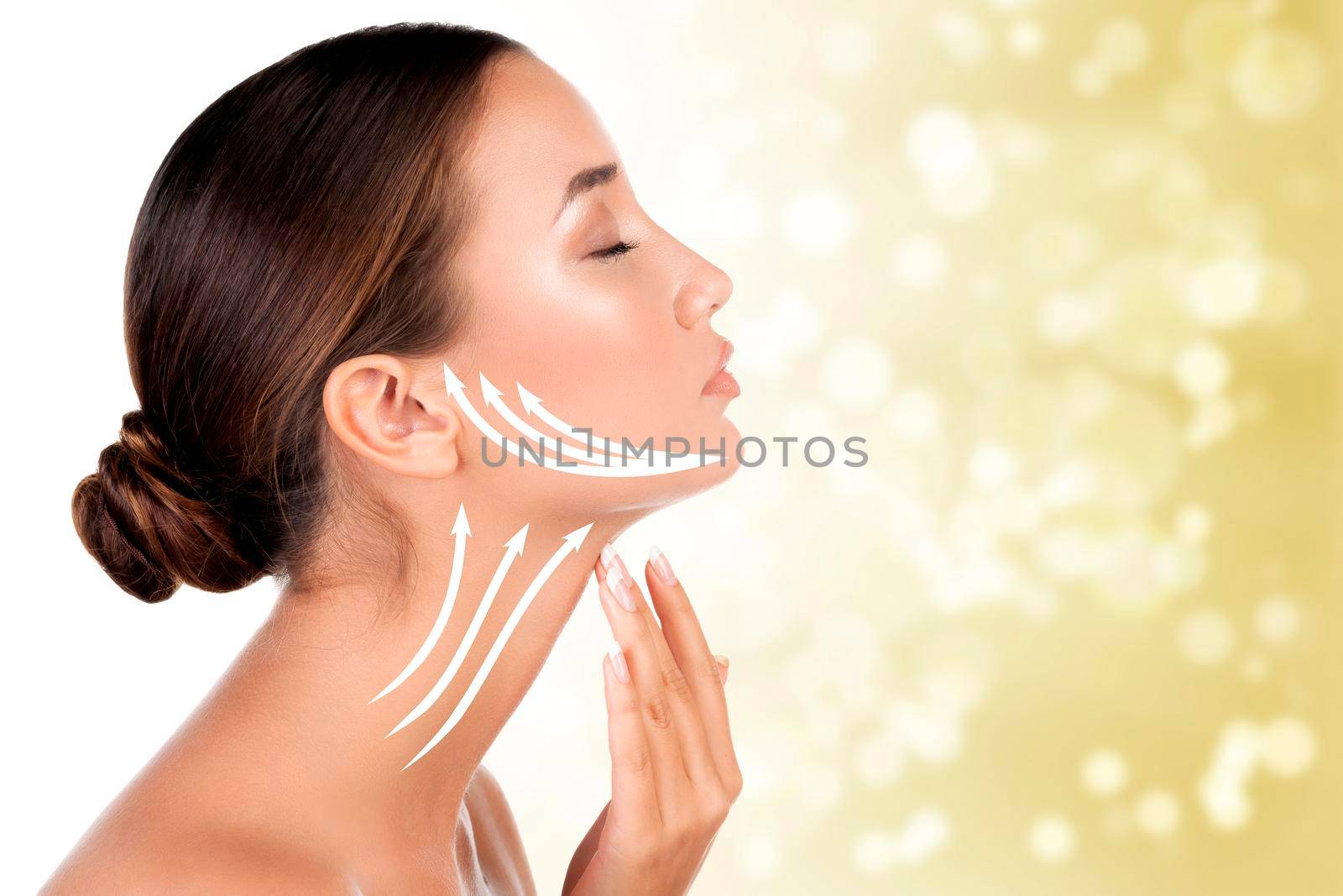 Pretty woman touching her neck on golden blurred background. Anti-aging concept.