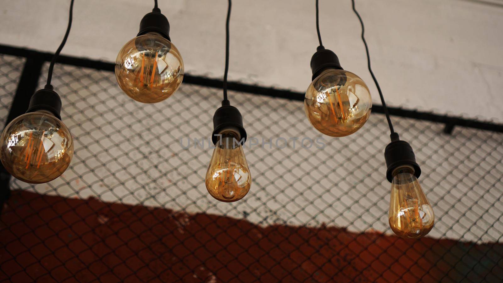 Decorative antique edison style light tungsten bulbs against the background of the wall with black mesh