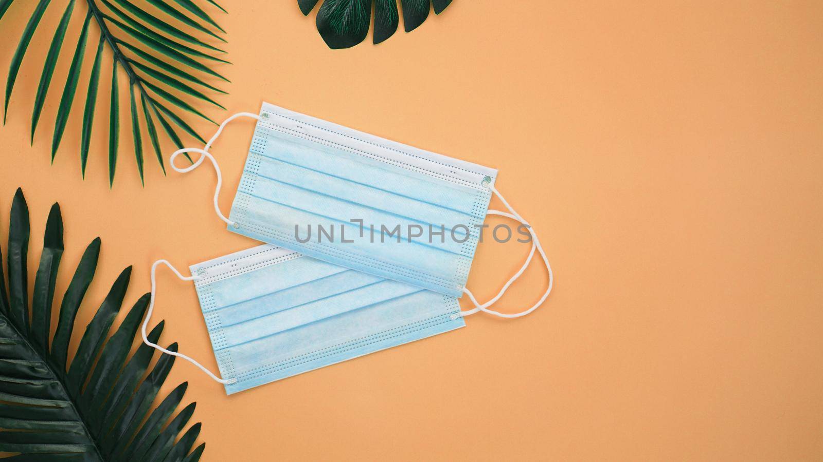 Protective medical masks on background with palm leaves. Concept vacation during the virus.