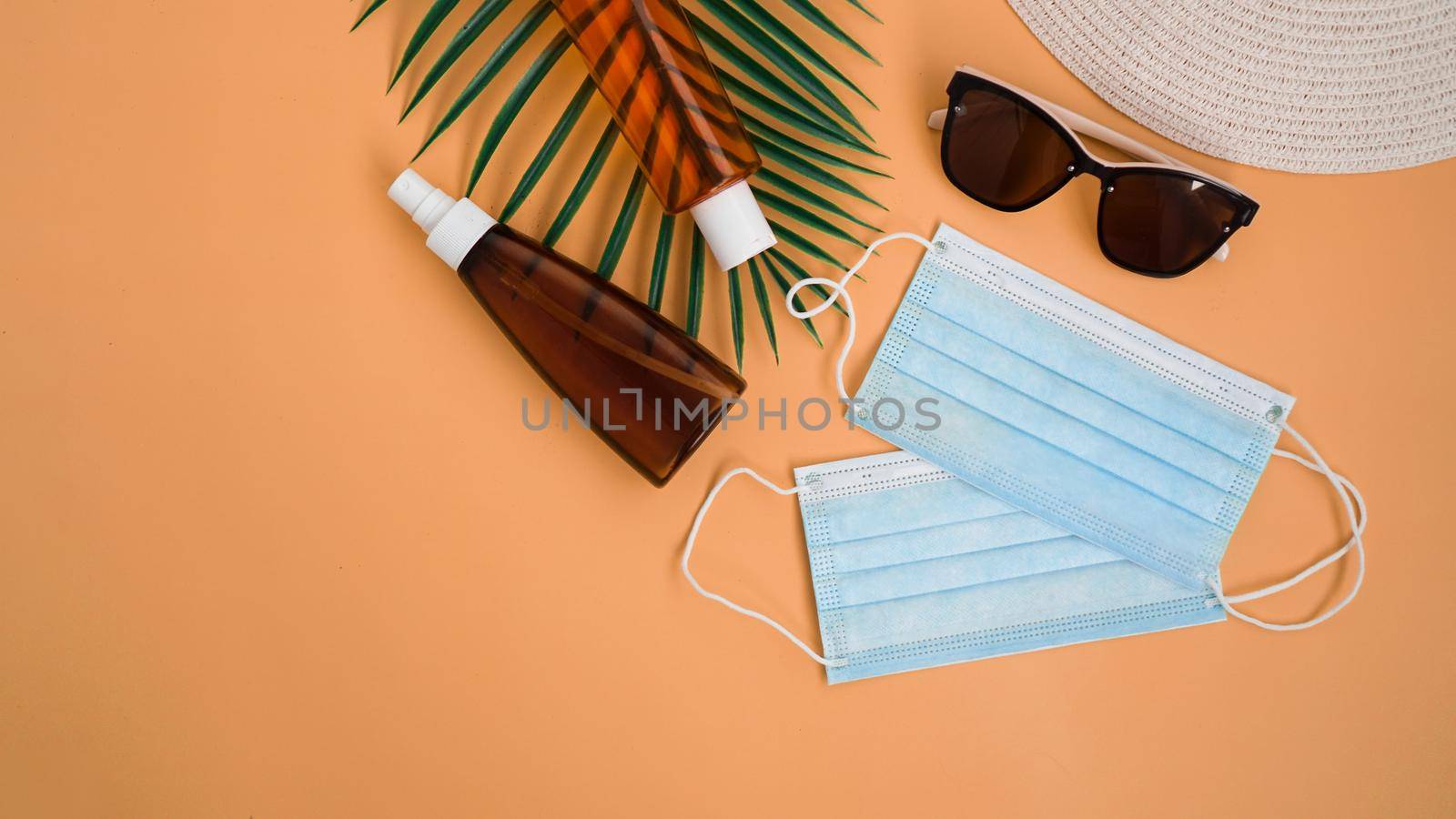Sun protection. Straw beach hat, sunglasses, protection spf cream, medical mask. Beach accessory. Summer travel in coronavirus quarantine concept