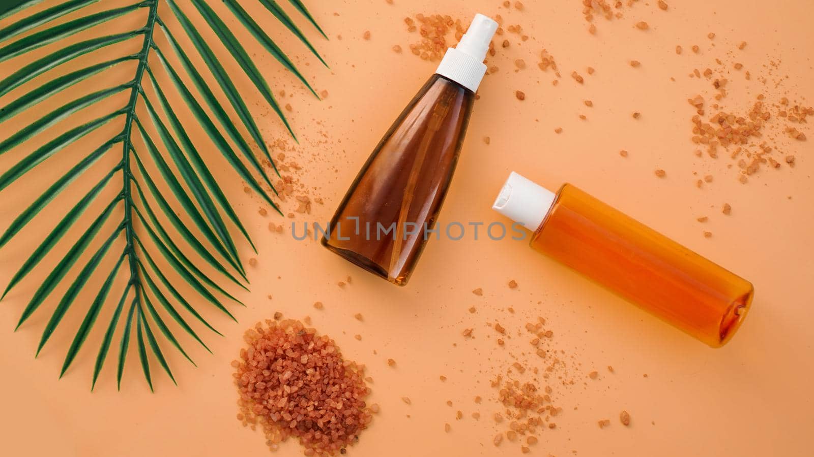 Summer skincare natural cosmetic products with green palm leaf background. Facial tonic and cream, sea salt. Home spa.