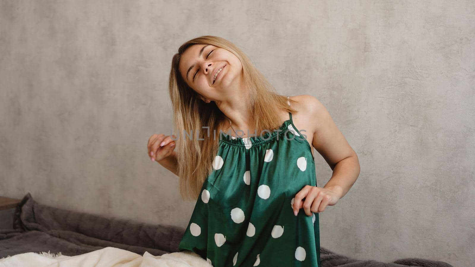 Beautiful smiling blonde in green pajamas. Good happy morning concept
