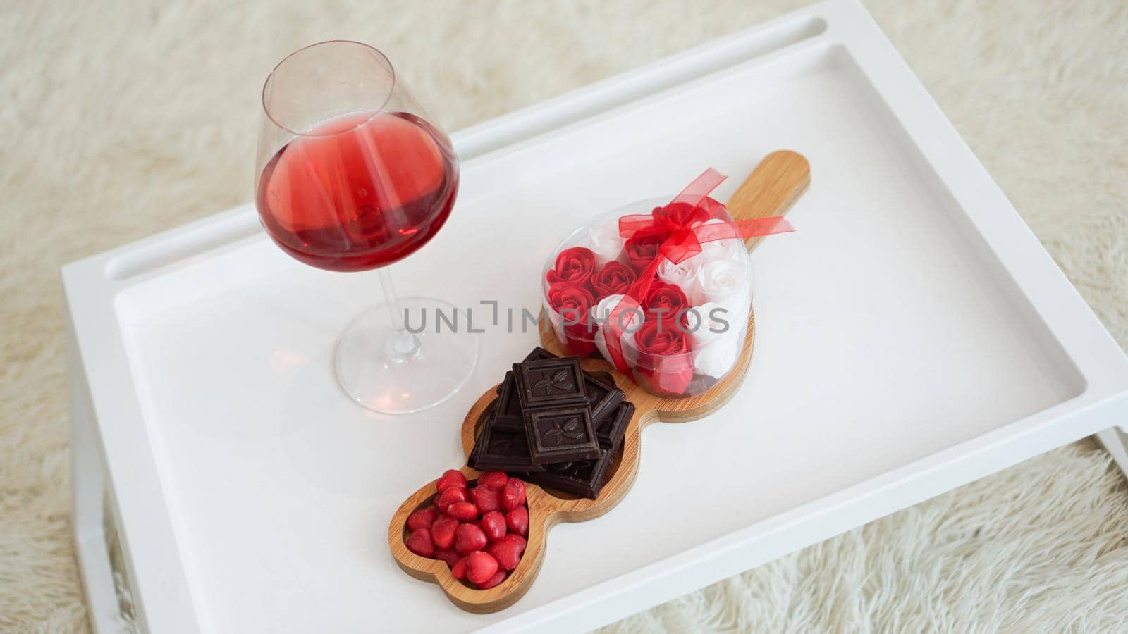 Breakfast for girlfriend. Valentines Day Morning. Wine and sweets on a white tray. Breakfast in bed.