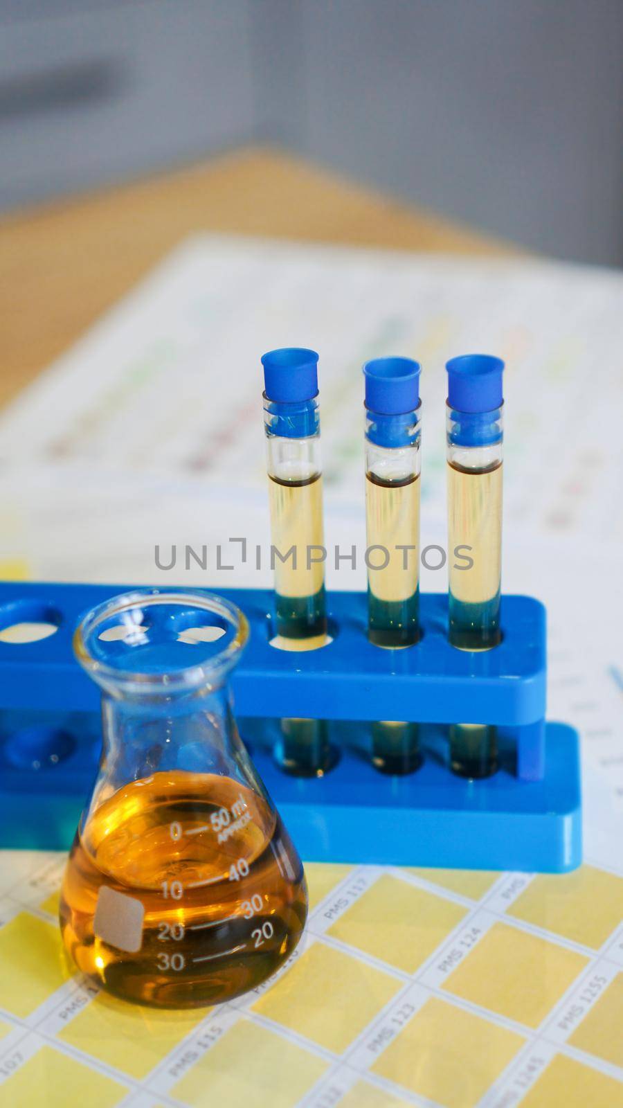 Flask and test tubes with urine on medical color schemes. The concept of laboratory analyzes, ph control. Vertical photo