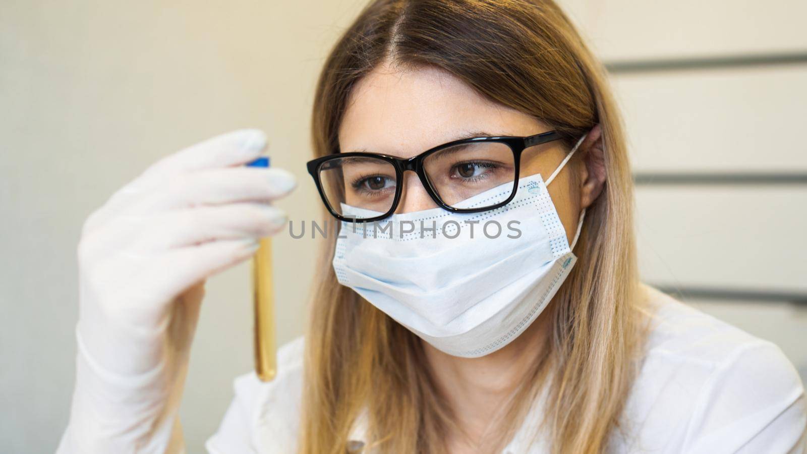 A woman holds a test tube with a urine test. Diagnostics and analysis concept. Health concept