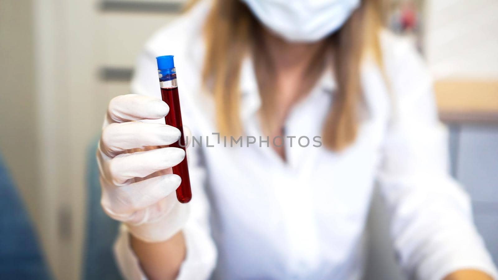 Close up of young female scientist holding test tube with blood sample by natali_brill
