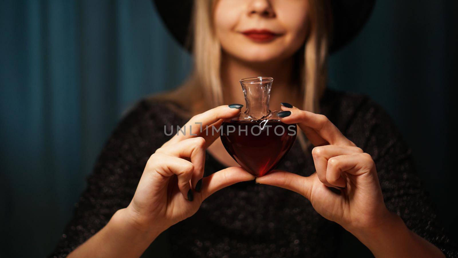 Cropped image of woman holding heart shaped glass jar of love potion by natali_brill