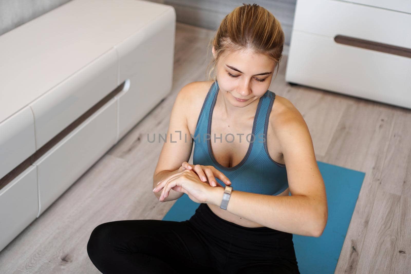 Portrait of young woman checking digital fitness tracker by natali_brill