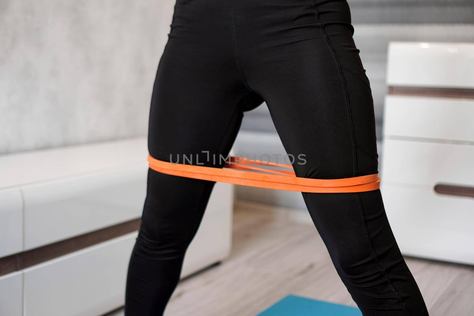 Woman during her fitness workout with rubber resistance band by natali_brill