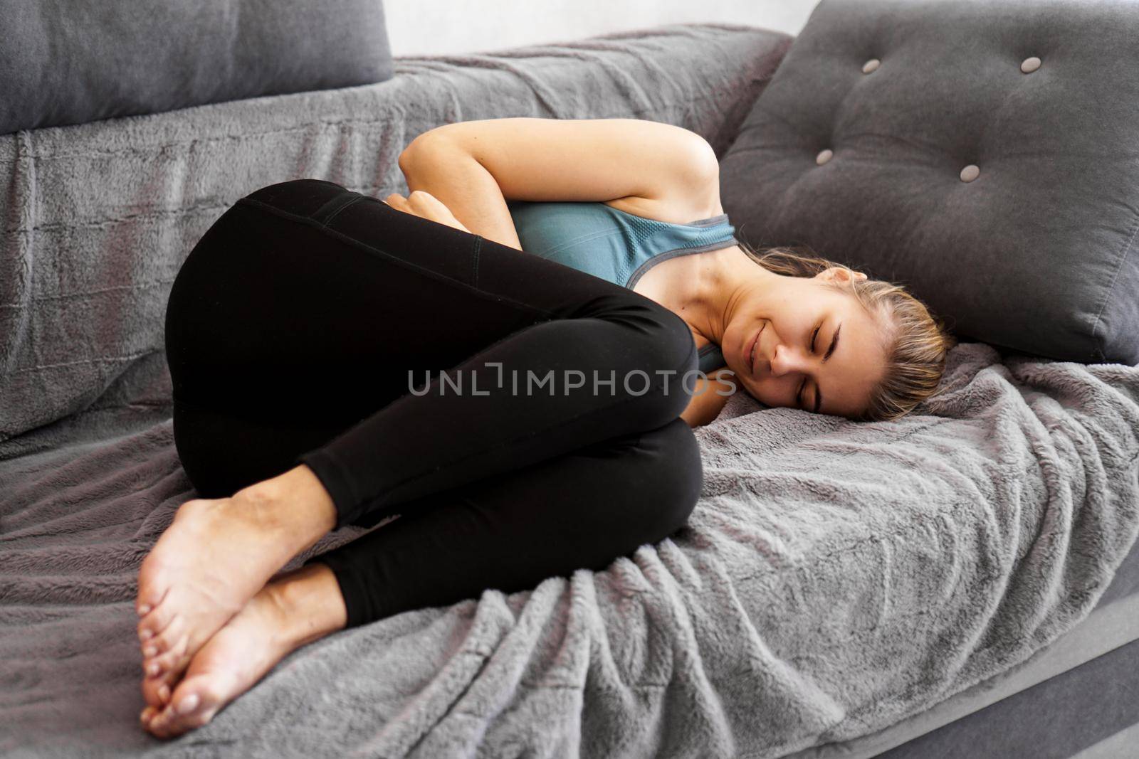 After the workout. Nice young woman sleeping on the sofa while being tired after sport training